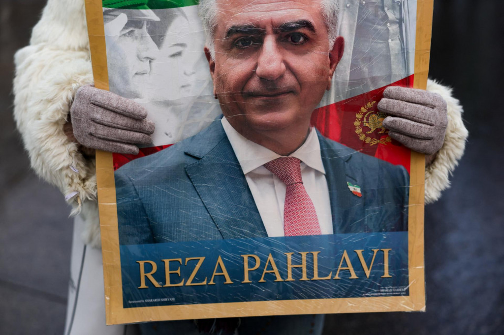 Protestuj&uacute;ci drž&iacute; transparent s vyobrazen&iacute;m Rezu Pahlav&iacute;ho, exilov&eacute;ho syna posledn&eacute;ho ir&aacute;nskeho &scaron;&aacute;ha a ir&aacute;nskej opozičnej osobnosti. FOTO: Reuters