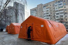 Pr&iacute;slu&scaron;n&iacute;k &Scaron;t&aacute;tnej z&aacute;chrannej služby Ukrajiny sa pozer&aacute; do stanu vl&aacute;dneho humanit&aacute;rneho centra, kde sa obyvatelia m&ocirc;žu zohriať, nabiť si zariadenia, z&iacute;skať tepl&eacute; n&aacute;poje a psychologick&uacute; podporu, ktor&yacute; je umiestnen&yacute; pred bytov&yacute;m domom počas v&yacute;padku pr&uacute;du po tom, čo ned&aacute;vne rusk&eacute; raketov&eacute; a bezpilotn&eacute; &uacute;toky zasiahli kritick&uacute; občiansku infra&scaron;trukt&uacute;ru. FOTO: REUTERS