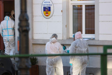 Person&aacute;l v ochrann&yacute;ch oblekoch pracuje v oblasti po streľbe na radnici. FOTO: REUTERS