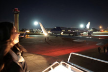 Zamestnanec Bieleho domu sa obzer&aacute; sp&auml;ť na Air Force One pri n&aacute;stupe do n&aacute;hradn&eacute;ho lietadla,. FOTO: Reuters