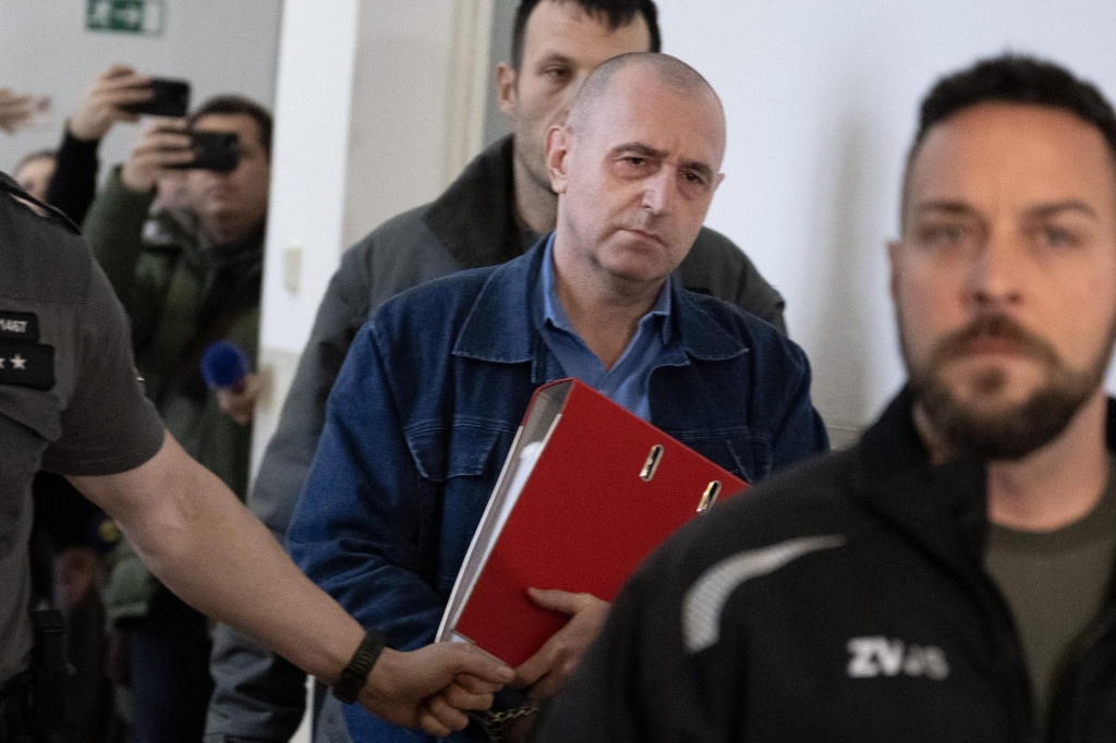 Na sn&iacute;mke uprostred obvinen&yacute; Jozef Radič prich&aacute;dza v sprievode justičnej str&aacute;že na pojedn&aacute;vanie v pr&iacute;pade vraždy zn&aacute;meho advok&aacute;ta Ernesta Valka.

FOTO: TASR/Pavel Neubauer