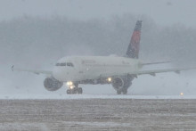 Lietadlo spoločnosti Delta Air Lines sa pripravuje na vzlet počas zimnej b&uacute;rky na medzin&aacute;rodnom letisku Greater Rochester v Rochesteri v &scaron;t&aacute;te New York. FOTO: Reuters