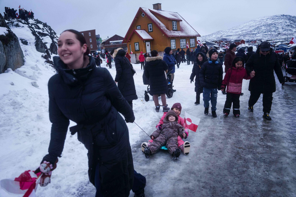 Na sn&iacute;mke žena ťah&aacute; svoje dieťa na boboch počas protestu proti Trumpovej politike voči Gr&oacute;nsku pred americk&yacute;m konzul&aacute;tom v Nuuku v Gr&oacute;nsku 17. janu&aacute;ra 2026. Americk&yacute; prezident Donald Trump v sobotu ozn&aacute;mil, že na osem eur&oacute;pskych kraj&iacute;n uval&iacute; od 1. febru&aacute;ra desaťpercentn&eacute; clo, ktor&eacute; bude platiť dovtedy, k&yacute;m sa nevyrie&scaron;i ot&aacute;zka z&iacute;skania Gr&oacute;nska Spojen&yacute;mi &scaron;t&aacute;tmi. Clo sa nesk&ocirc;r m&ocirc;že zv&yacute;&scaron;iť až na 25 percent. FOTO TASR/AP
