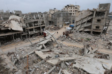 Palest&iacute;nčania kr&aacute;čaj&uacute; obklopen&iacute; troskami domov zničen&yacute;ch pri izraelsk&yacute;ch &uacute;tokoch počas vojny v Ch&aacute;n J&uacute;nis v južnom P&aacute;sme Gazy. FOTO: Reuters