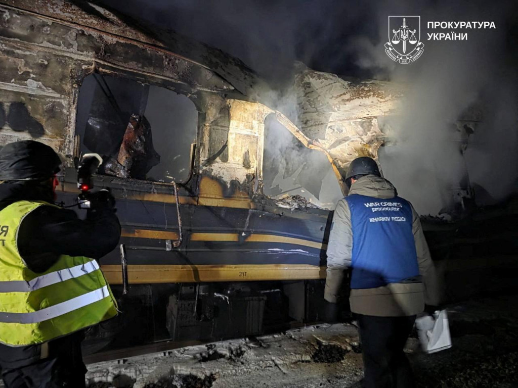 Prokur&aacute;tor pre vojnov&eacute; zločiny a policajt pracuj&uacute; vedľa osobn&eacute;ho vlaku zasiahnut&eacute;ho rusk&yacute;m dronom v Charkovskej oblasti na Ukrajine. FOTO: REUTERS