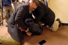 Muži zr&aacute;žaj&uacute; na zem &uacute;točn&iacute;ka, ktor&yacute; l&aacute;tkou posprejoval členku americkej Snemovne reprezentantov Ilhanu Omarov&uacute;. FOTO: TASR/AP