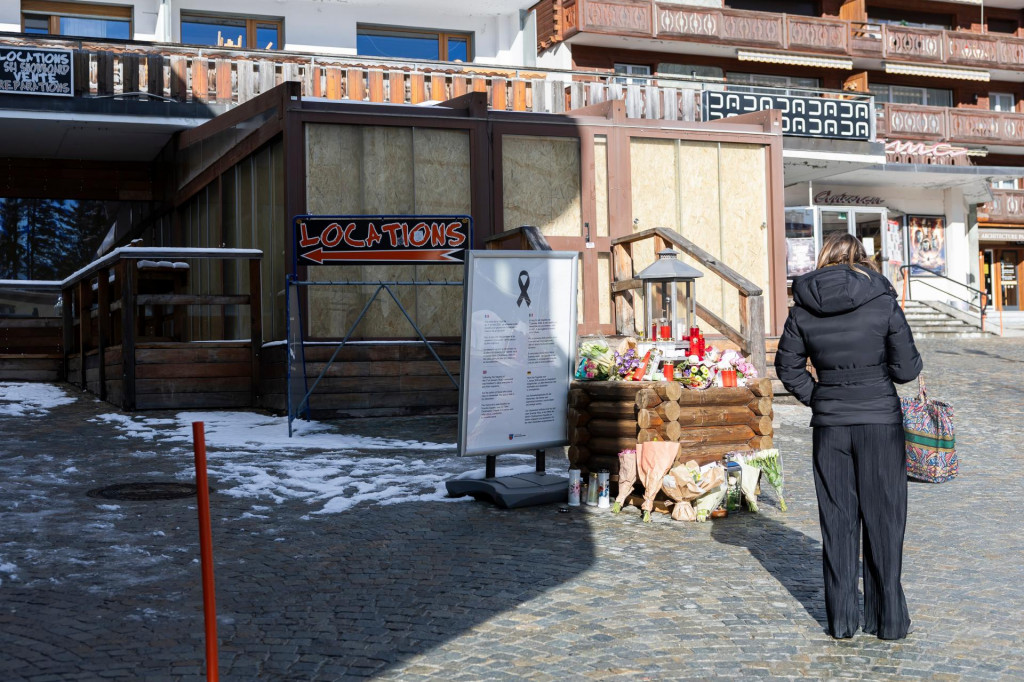 Žena stoj&iacute; pred barom v luxusnom &scaron;vajčiarskom lyžiarskom stredisku Crans Montana ležiacom v kanton&aacute;lne Valais, kde pri novoročnom požiari zahynulo 40 ľud&iacute;. FOTO: TASR/AP