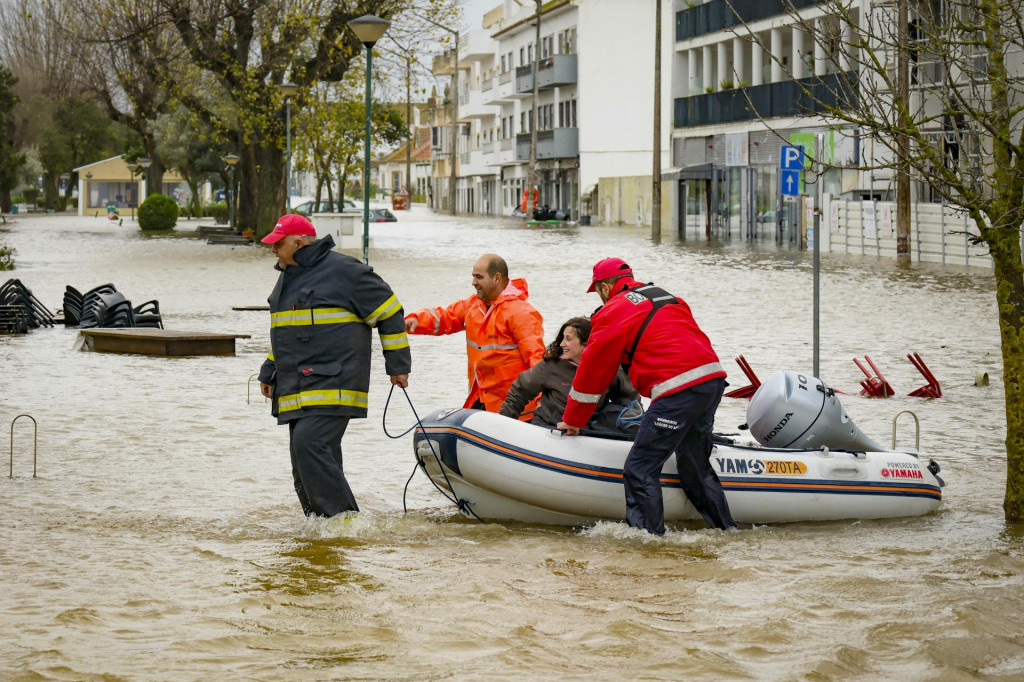 Hasiči evakuuj&uacute; na gumennom člne ľud&iacute; v zaplavenej portugalskej obci Alc&aacute;cer do Sal. FOTO: TASR/Lusa
