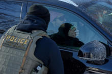 Na arch&iacute;vnej sn&iacute;mke muž sediaci v aute smeruje cez okno kameru svojho mobiln&eacute;ho telef&oacute;nu na protiimigračn&eacute;ho agenta v Minneapolise. FOTO: TASR/AP