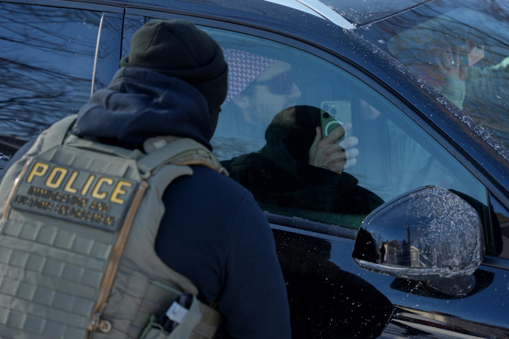 Na arch&iacute;vnej sn&iacute;mke muž sediaci v aute smeruje cez okno kameru svojho mobiln&eacute;ho telef&oacute;nu na protiimigračn&eacute;ho agenta v Minneapolise. FOTO: TASR/AP