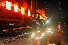 Hasiči sa snažia uhasiť požiar po ruskom dronovom &uacute;toku na osobn&yacute; vlak v Charkovskej oblasti na severov&yacute;chode Ukrajiny. FOTO: TASR/AP