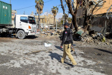 Policajt prech&aacute;dza okolo &scaron;k&ocirc;d na mieste po &uacute;tokoch militantov v najv&auml;č&scaron;om meste Kv&eacute;ta v pakistanskej provincii Bal&uacute;čistan. FOTO: Reuters