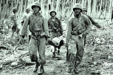 Americk&iacute; vojaci pri evaku&aacute;cii zranen&eacute;ho spolubojovn&iacute;ka z džungle počas bojov na ostrove Guadalcanal.