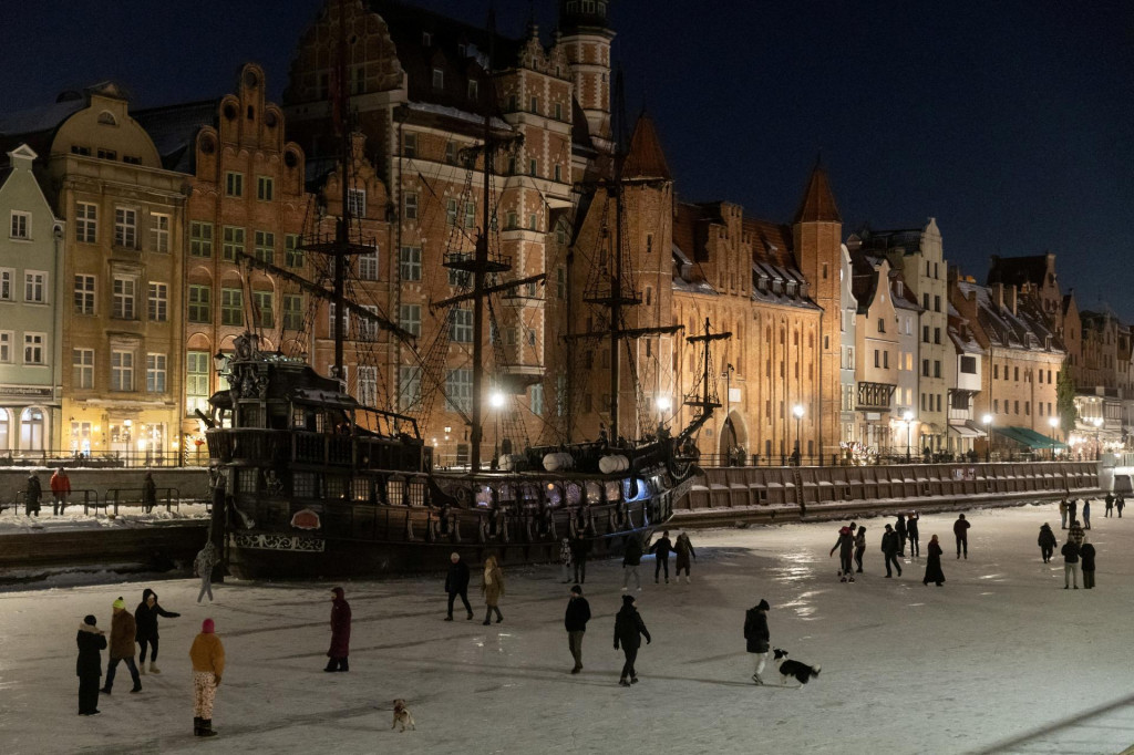 Ľudia sa prech&aacute;dzaj&uacute; a korčuľuj&uacute; na zamrznutej rieke Motława v Gdansku. FOTO: Reuters