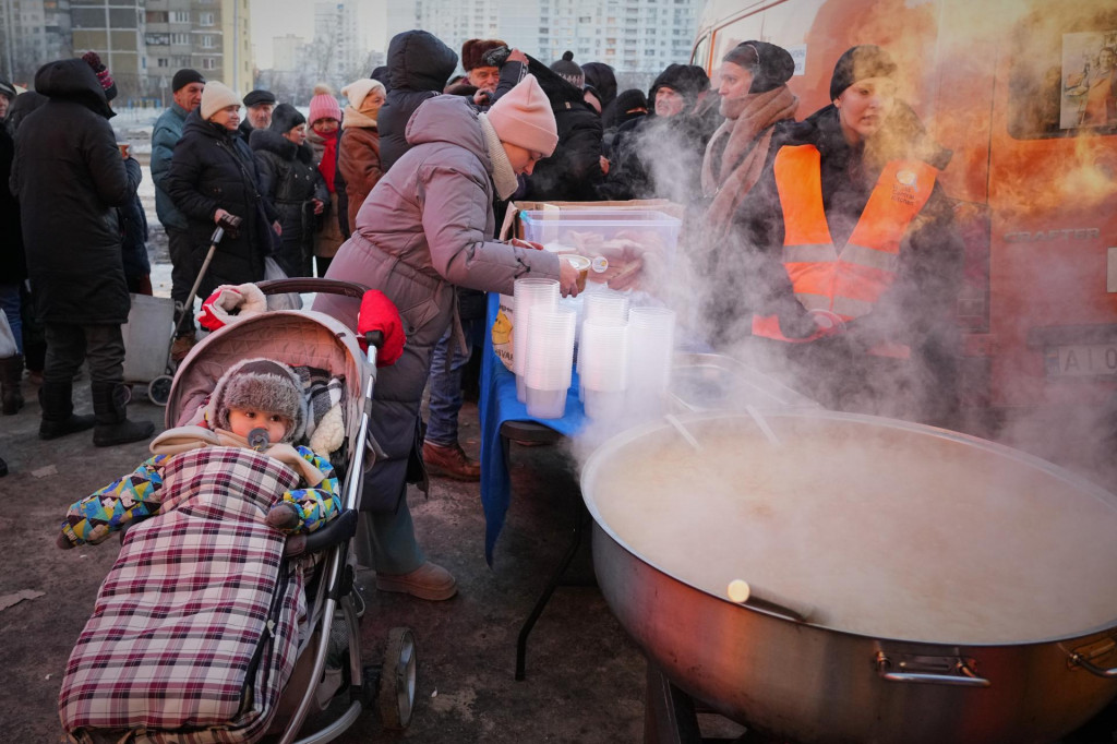 Ukrajinka Julija Dolotovov&aacute; dost&aacute;va tepl&eacute; jedlo v distribučnom centre počas v&yacute;padku elektrickej energie po pravideln&yacute;ch rusk&yacute;ch &uacute;tokoch na energetiku v Kyjeve. FOTO: TASR/AP