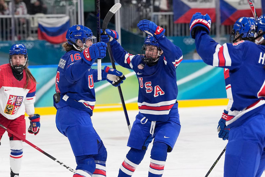 Rusk&aacute; vlajka v pozad&iacute; za hokejistkami Česka a USA. FOTO: TASR/AP