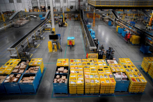 Pracovn&iacute;ci vyberaj&uacute; a balia tovar objedn&aacute;vok Amazonu. FOTO: Reuters