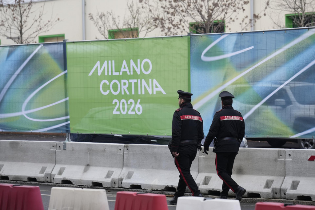 Policajti kr&aacute;čaj&uacute; okolo olympijskej dediny v Mil&aacute;ne. FOTO: TASR/AP
