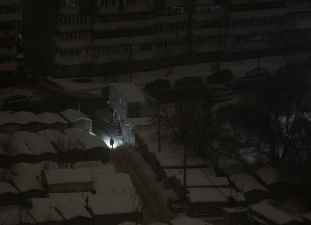 Obyvateľ použ&iacute;va baterku pri ch&ocirc;dzi počas v&yacute;padku pr&uacute;du po tom, čo rusk&eacute; raketov&eacute; a bezpilotn&eacute; &uacute;toky zasiahli kritick&uacute; občiansku infra&scaron;trukt&uacute;ru v Kyjeve. FOTO: Reuters