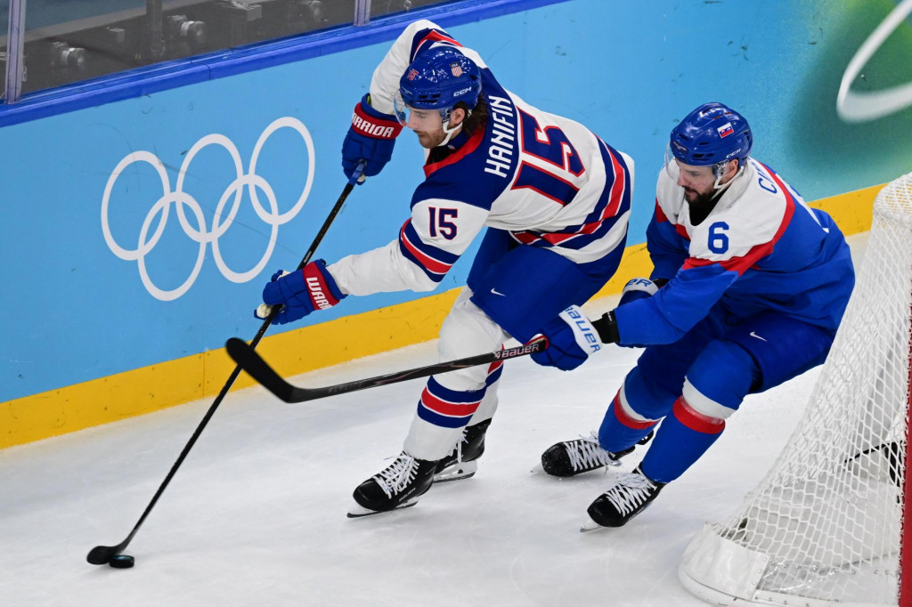 Sprava Luk&aacute;&scaron; Cingel (Slovensko) a Noah Hanifin (USA) bojuj&uacute; o puk v semifin&aacute;lovom z&aacute;pase v ľadovom hokeji USA - Slovensko na zimn&yacute;ch olympijsk&yacute;ch hr&aacute;ch 2026 v Mil&aacute;ne. FOTO: TASR/Jaroslav Nov&aacute;k