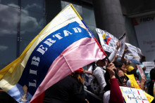 Žena drž&iacute; venezuelsk&uacute; vlajku s n&aacute;pisom &bdquo;Sloboda&ldquo;. FOTO: Reuters