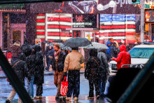 Ľudia prech&aacute;dzaj&uacute; po Times Square počas snehovej b&uacute;rky v New Yorku. FOTO: Reuters