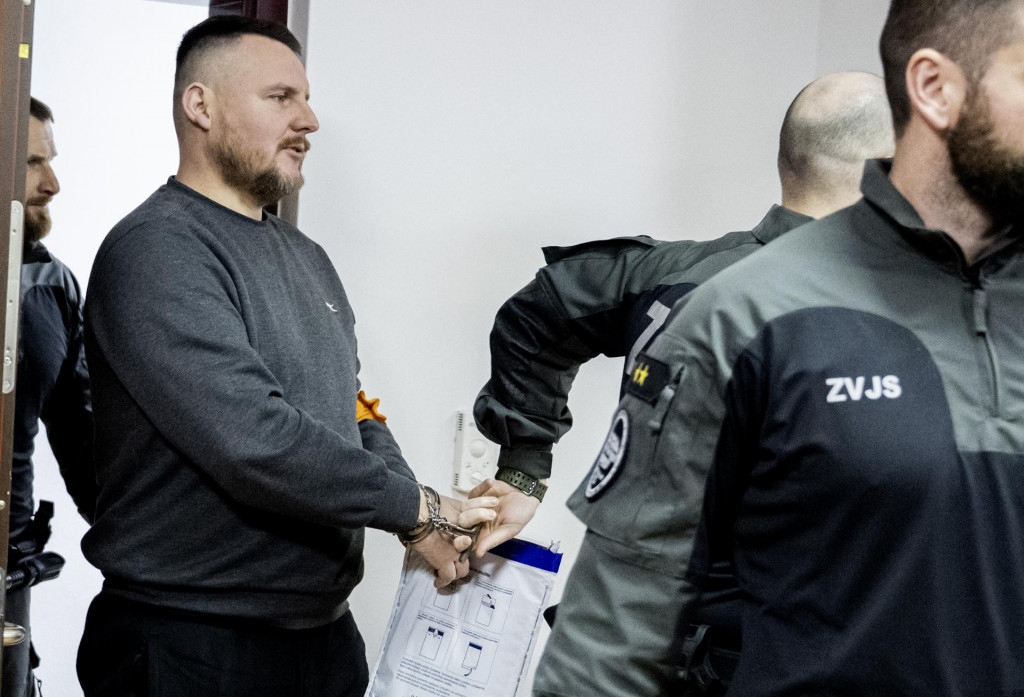Daniel Bombic v sprievode justičnej str&aacute;že prich&aacute;dza na s&uacute;dne pojedn&aacute;vanie na &Scaron;pecializovanom trestnom s&uacute;de v Pezinku. FOTO: TASR/Martin Baumann