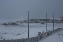Pluhy odhŕňaj&uacute; sneh z asfaltovej plochy počas snehovej b&uacute;rky na letisku LaGuardia v New Yorku. FOTO: REUTERS