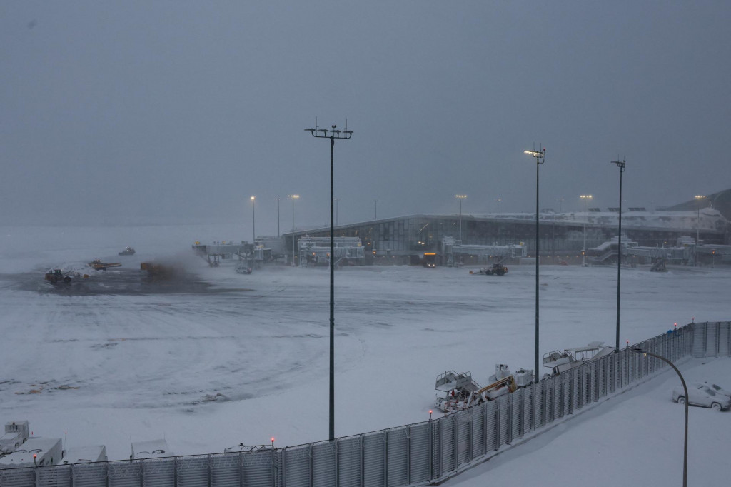 Pluhy odhŕňaj&uacute; sneh z asfaltovej plochy počas snehovej b&uacute;rky na letisku LaGuardia v New Yorku. FOTO: REUTERS
