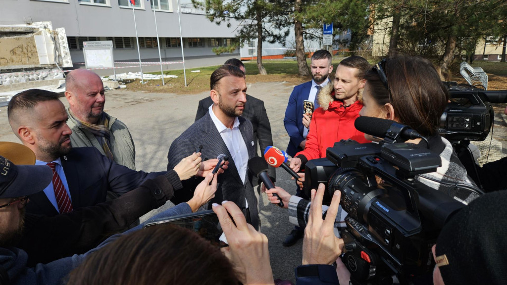 Z budovy Klientskeho centra na Z&aacute;hradn&iacute;ckej ulici v Kom&aacute;rne spadla časť strechy. Pri trag&eacute;dii pri&scaron;la o život jedna osoba, ďal&scaron;ie dve utrpeli zranenia. Na mieste zasahovali v&scaron;etky z&aacute;chrann&eacute; zložky. Na sn&iacute;mke uprostred minister vn&uacute;tra SR Mat&uacute;&scaron; &Scaron;utaj E&scaron;tok (Hlas-SD) hovor&iacute; s novin&aacute;rmi pred budovou Klientskeho centra v Kom&aacute;rne 25. febru&aacute;ra 2026. FOTO TASR - Milan Drozd FOTO: Milan Drozd