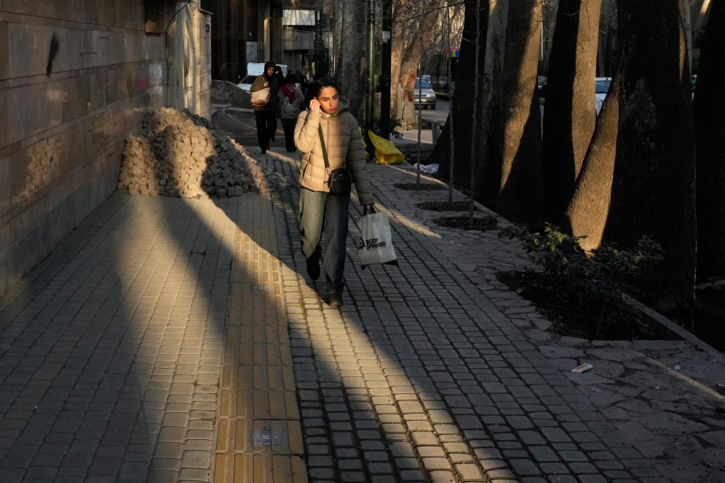 Ľudia kr&aacute;čaj&uacute; po chodn&iacute;ku v severnej časti ir&aacute;nskej metropoly Teher&aacute;n. FOTO: TASR/AP