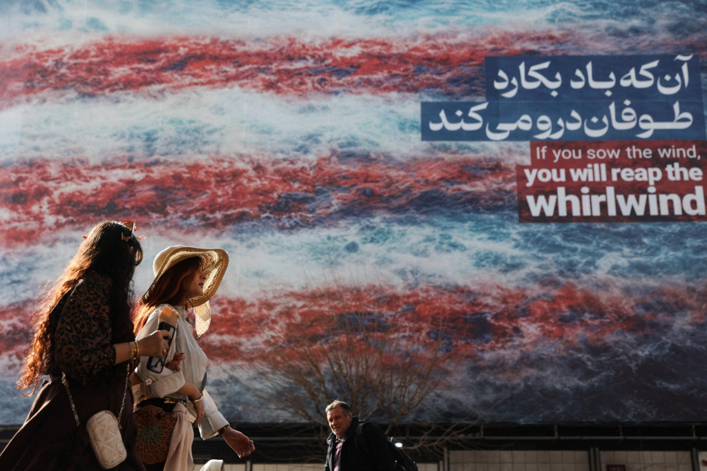 Ir&aacute;nske ženy prech&aacute;dzaj&uacute; okolo billboardu namieren&eacute;ho proti USA v Teher&aacute;ne. FOTO: Reuters
