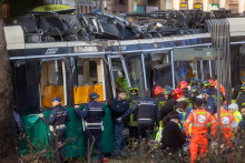 Hasiči a policajti zasahuj&uacute; na mieste nehody električky v Mil&aacute;ne. FOTO: TASR/AP