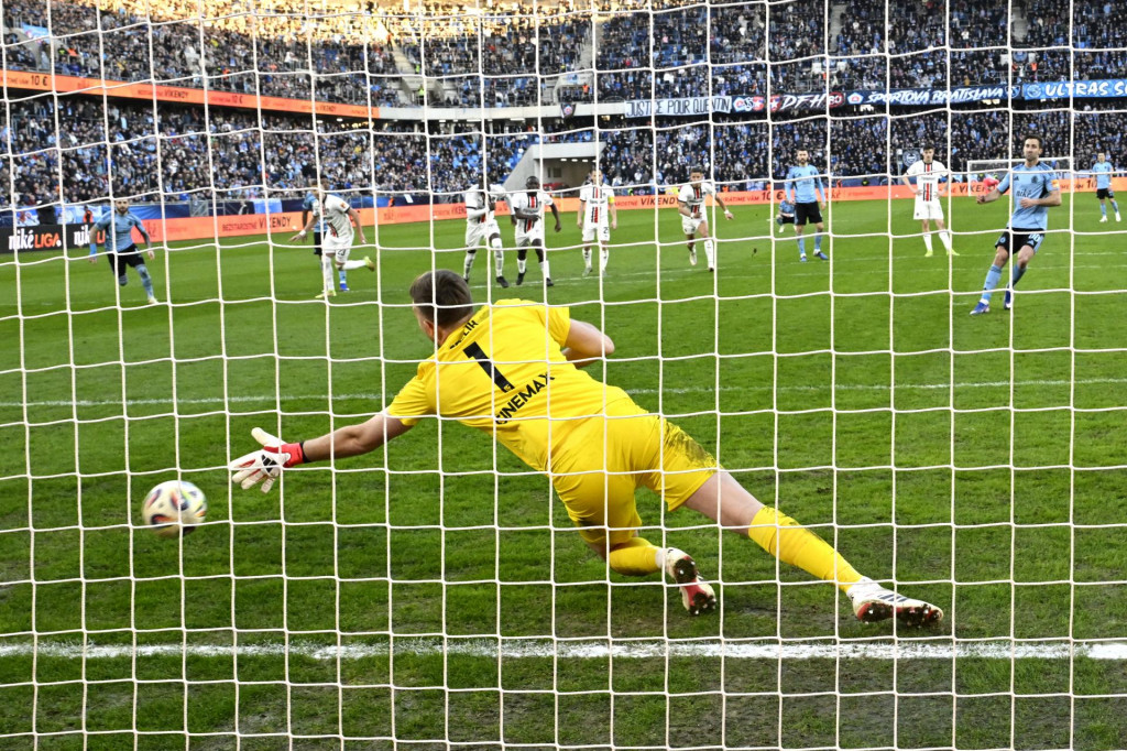Na sn&iacute;mke v pozad&iacute; vpravo Andaž &Scaron;porar (Slovan) stieľa g&oacute;l z pokutov&eacute;ho kopu brank&aacute;rovi Žigovi Frelihovi (Trnava) v z&aacute;verečnom 22. kole z&aacute;kladnej časti Nik&eacute; ligy &Scaron;K Slovan Bratislava - FC Spartak Trnava. FOTO: TASR/Pavel Neubauer