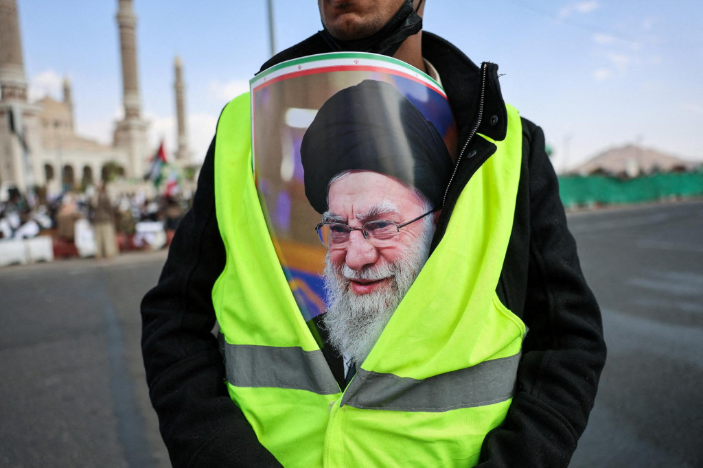 Muž s transparentom vo vn&uacute;tri bundy s fotografiou zosnul&eacute;ho ir&aacute;nskeho najvy&scaron;&scaron;ieho vodcu ajatoll&aacute;ha Al&iacute;ho Chamene&iacute;ho sa z&uacute;častňuje protestu proti Izraelu a americk&yacute;m &uacute;tokom na Ir&aacute;n. FOTO: REUTERS