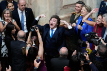 Argent&iacute;nsky prezident Javier Milei (uprostred) gestikuluje počas pr&iacute;chodu do budovy parlamentu v Buenos Aires v nedeľu 1. marca 2026. FOTO: TASR/AP