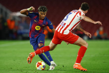 Lamine Yamal z FC Barcelona v akcii s Matteom Ruggerim z Atl&eacute;tica Madrid. FOTO: REUTERS