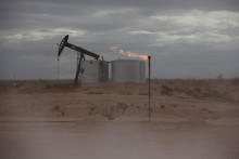 FILE PHOTO: Dust blows around a crude oil pump jack and flare burning excess gas at a drill pad in the Permian Basin in Loving County, Texas, U.S. November 25, 2019. Picture taken November 25, 2019. REUTERS/Angus Mordant/File Photo FOTO: Angus Mordant