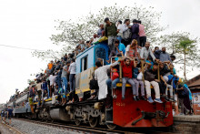 Ľudia v Banglad&eacute;&scaron;i cestuj&uacute;ci vlakom. FOTO: REUTERS