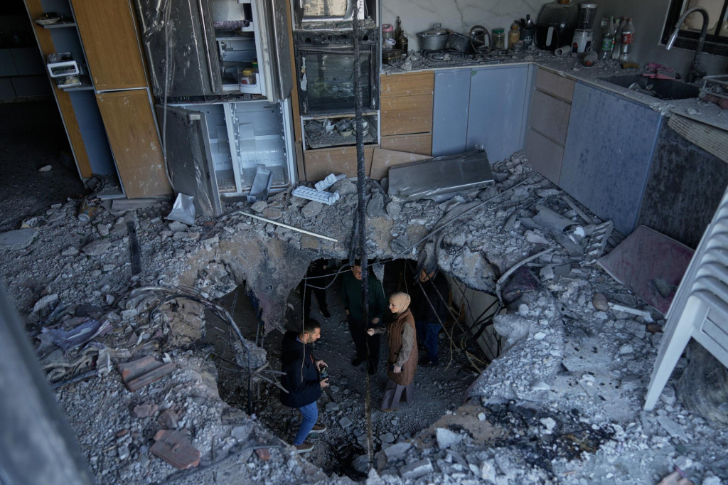 Palest&iacute;nski obyvatelia sk&uacute;maj&uacute; &scaron;kody v zničenom byte trojposchodovej obytnej budovy, ktor&uacute; sp&ocirc;sobili &uacute;lomky ir&aacute;nskej rakety po odvetnom raketovom &uacute;toku Ir&aacute;nu na Izrael v meste Biddja, na Z&aacute;padnom brehu Jord&aacute;nu. FOTO: TASR/AP