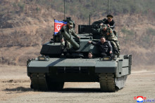Severok&oacute;rejsk&yacute; vodca Kim Čong-un (tret&iacute; zľava) a jeho dc&eacute;ra Kim Čchu-e (druh&aacute; zľava) sa prev&aacute;žaj&uacute; na novom tanku na z&aacute;kladni v Pchjongjangu. FOTO: TASR/AP
