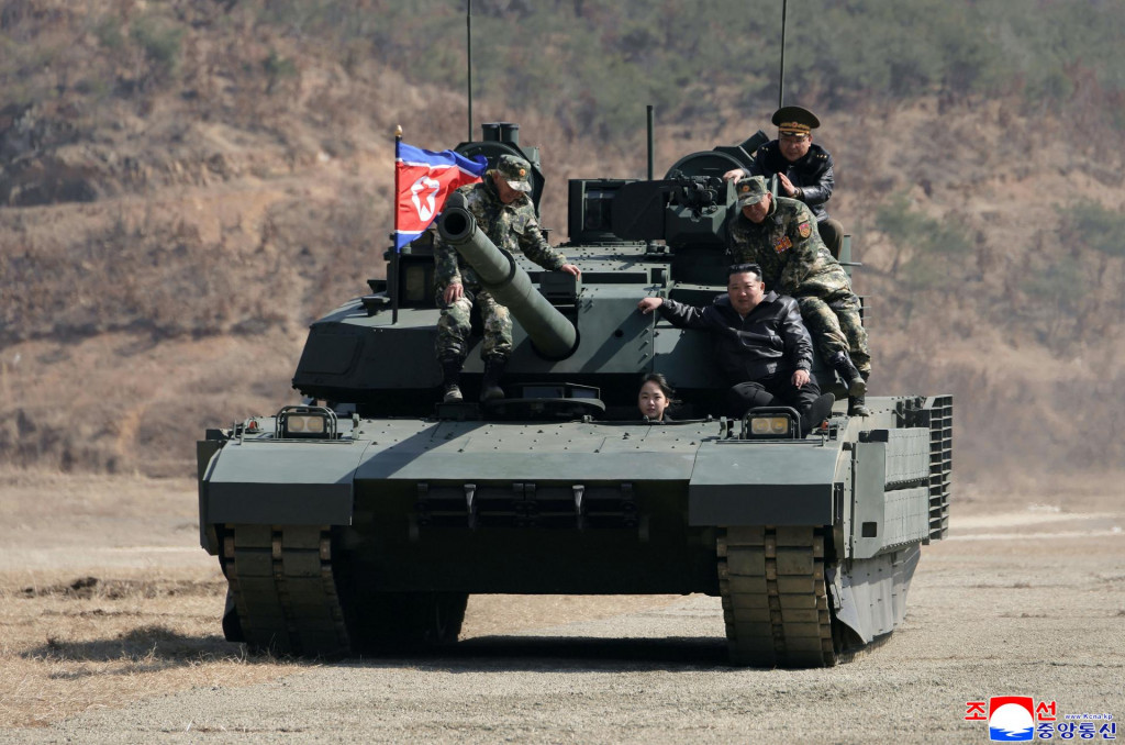 Severok&oacute;rejsk&yacute; vodca Kim Čong-un (tret&iacute; zľava) a jeho dc&eacute;ra Kim Čchu-e (druh&aacute; zľava) sa prev&aacute;žaj&uacute; na novom tanku na z&aacute;kladni v Pchjongjangu. FOTO: TASR/AP

