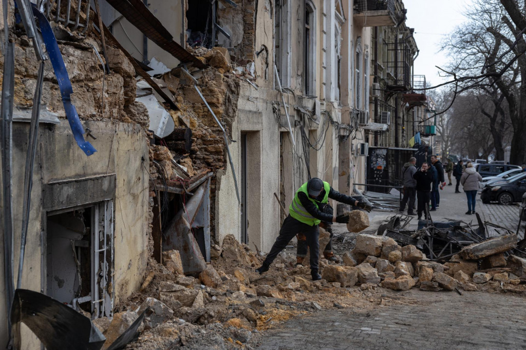 Mestsk&yacute; zamestnanec odstraňuje trosky z obytnej budovy, ktor&uacute; zasiahol dronov&yacute; &uacute;tok ruskej arm&aacute;dy v ukrajinskom meste Odesa vo &scaron;tvrtok 19. marca 2026. FOTO: TASR/AP