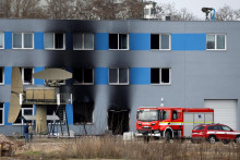 Hasičsk&eacute; auto stoj&iacute; pred horiacou v&yacute;robnou halou v priemyselnej z&oacute;ne v Pardubiciach. FOTO: Reuters