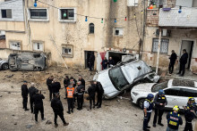 Izraelsk&eacute; z&aacute;chrann&eacute; zložky, bezpečnostn&iacute; &uacute;radn&iacute;ci a obyvatelia sa zhromaždili na mieste dopadu rakety v meste Kafr K&aacute;sem. FOTO: Reuters