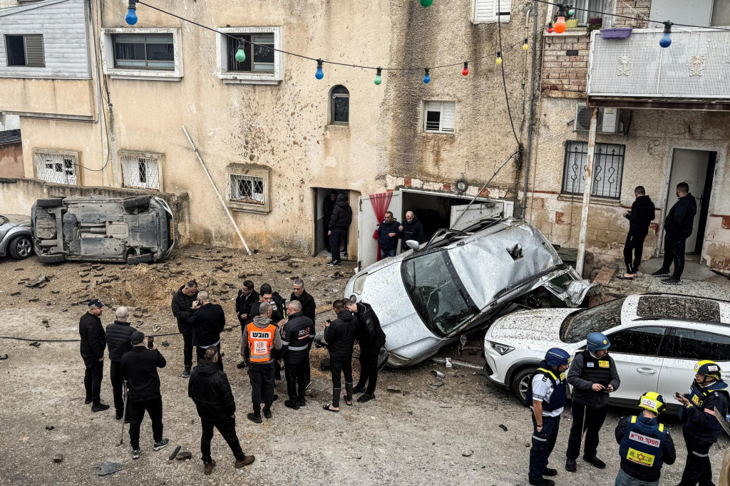 Izraelsk&eacute; z&aacute;chrann&eacute; zložky, bezpečnostn&iacute; &uacute;radn&iacute;ci a obyvatelia sa zhromaždili na mieste dopadu rakety v meste Kafr K&aacute;sem. FOTO: Reuters
