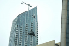 Pracovnic&iacute; prezeraj&uacute; zničen&uacute; časť hotela Address Creek Harbour, ktor&yacute; bol zasiahnut&yacute; ir&aacute;nskym dronom v Dubaji (12. marca 2026). FOTO: TASR/AP