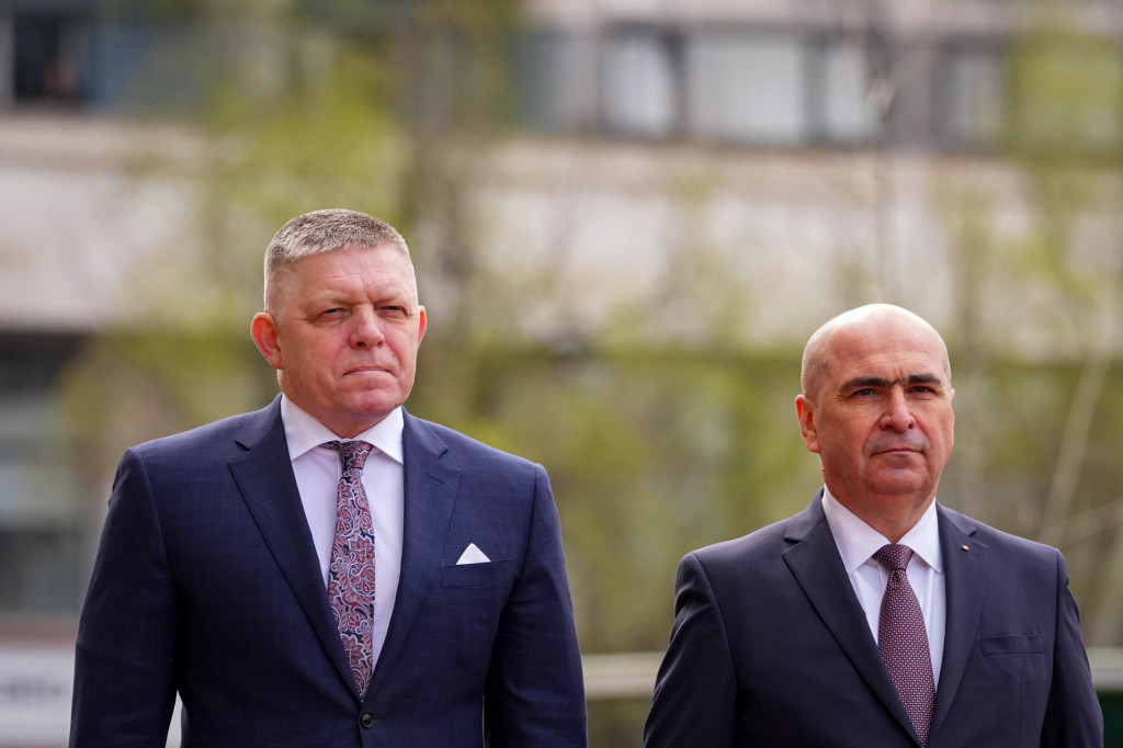 Slovensk&yacute; premi&eacute;r Robert Fico (vľavo) a jeho rumunsk&yacute; n&aacute;protivok Ilie Bolojan p&oacute;zuj&uacute; počas uv&iacute;tacieho ceremoni&aacute;lu v Bukure&scaron;ti. FOTO: TASR/AP