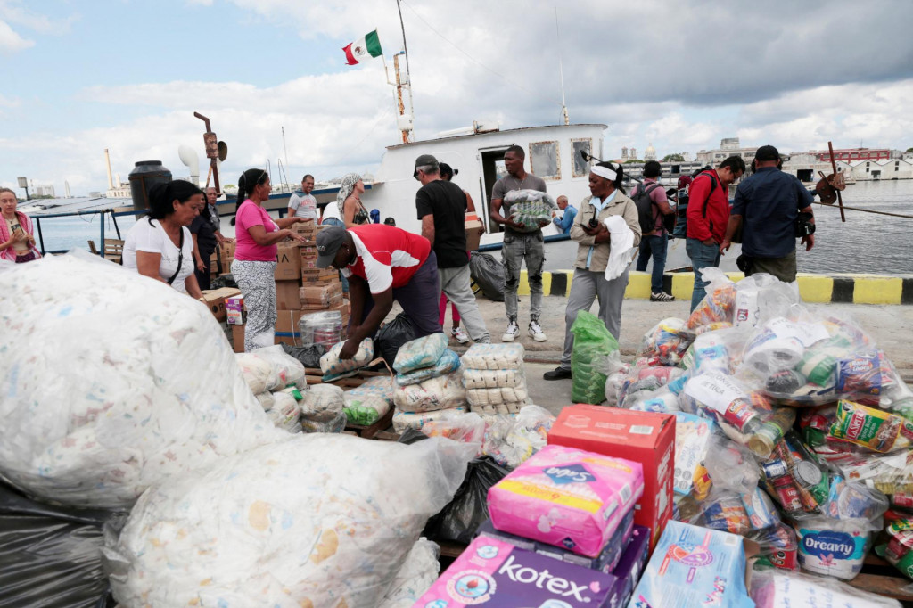 Členovia flotily, ktor&aacute; odpl&aacute;vala z Mexika, spolu s miestnymi pr&iacute;stavn&yacute;mi pracovn&iacute;kmi vykladaj&uacute; humanit&aacute;rnu pomoc po pr&iacute;chode do Havansk&eacute;ho z&aacute;livu. FOTO: Reuters