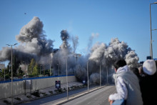 Okoloid&uacute;ci sa pozeraj&uacute; ako dym st&uacute;pa z miesta izraelsk&yacute;ch leteck&yacute;ch &uacute;tokov na obytn&uacute; budovu pri ceste na letisko v Bejr&uacute;te. FOTO: TASR/AP